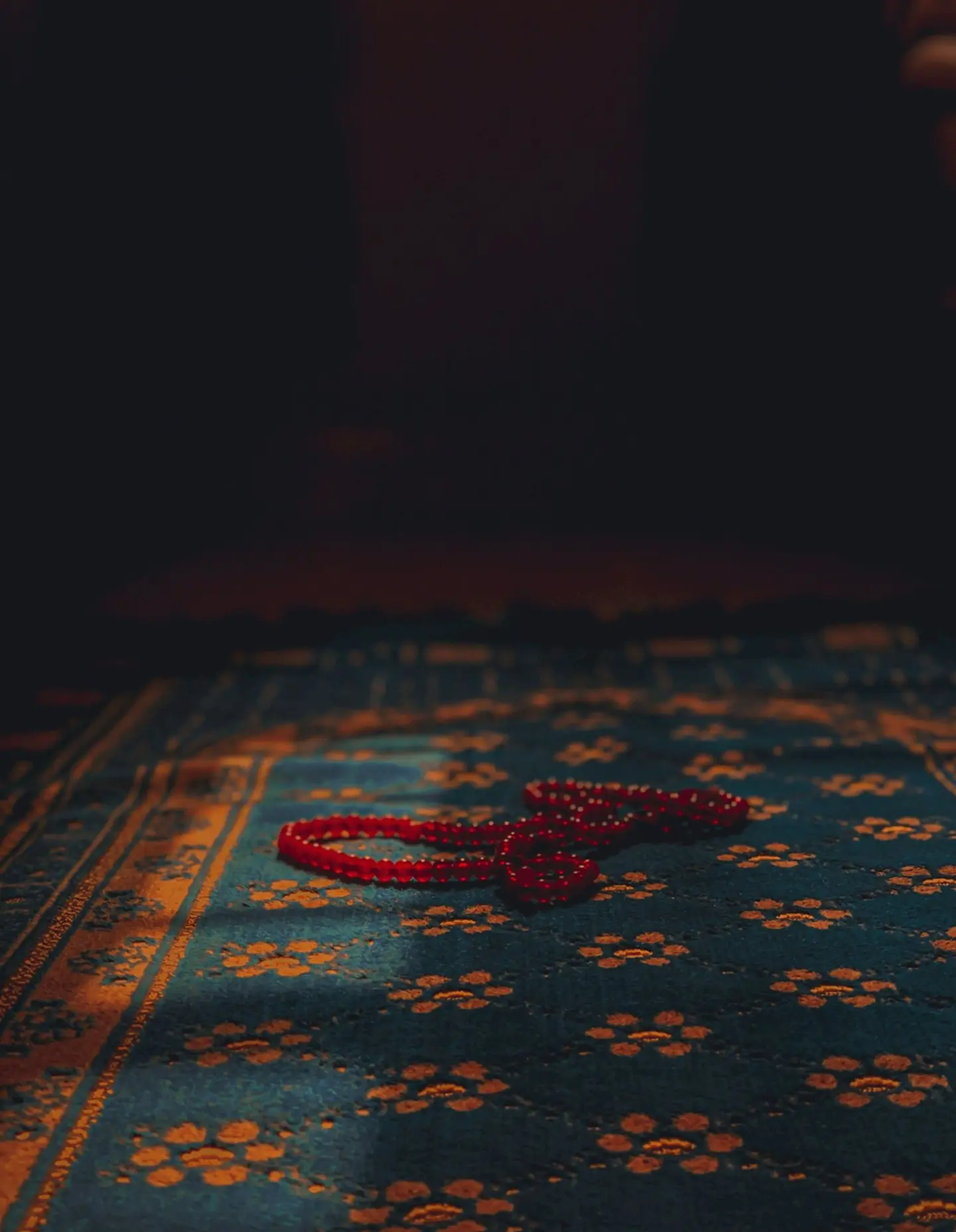 a red string laying on top of a blue rug